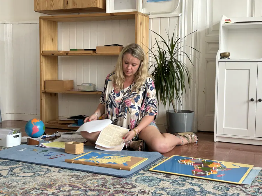 a guide presenting map materials laid out on the floor