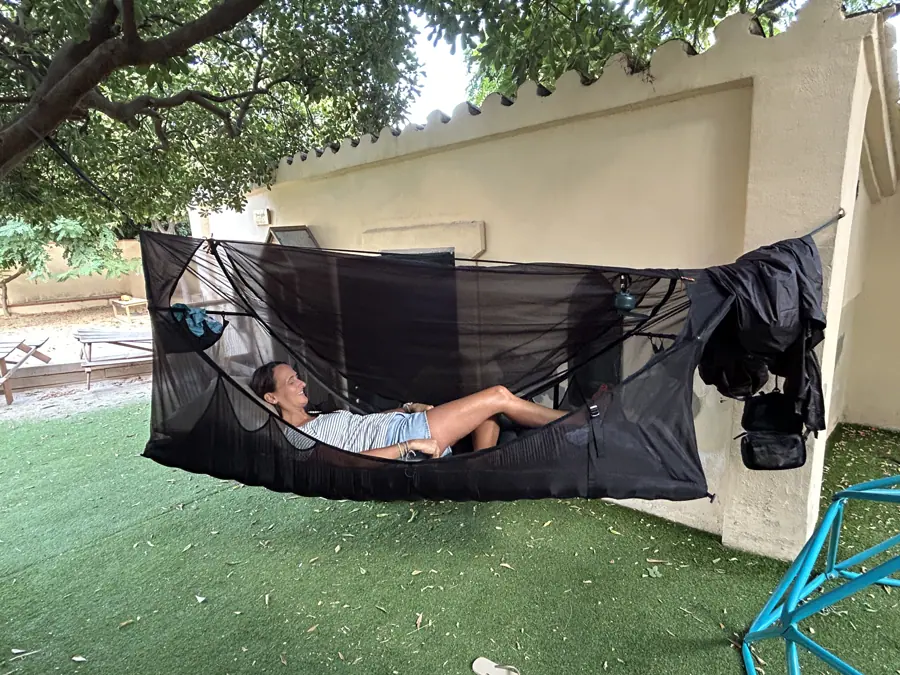 a hammock strung between garden walls under the trees