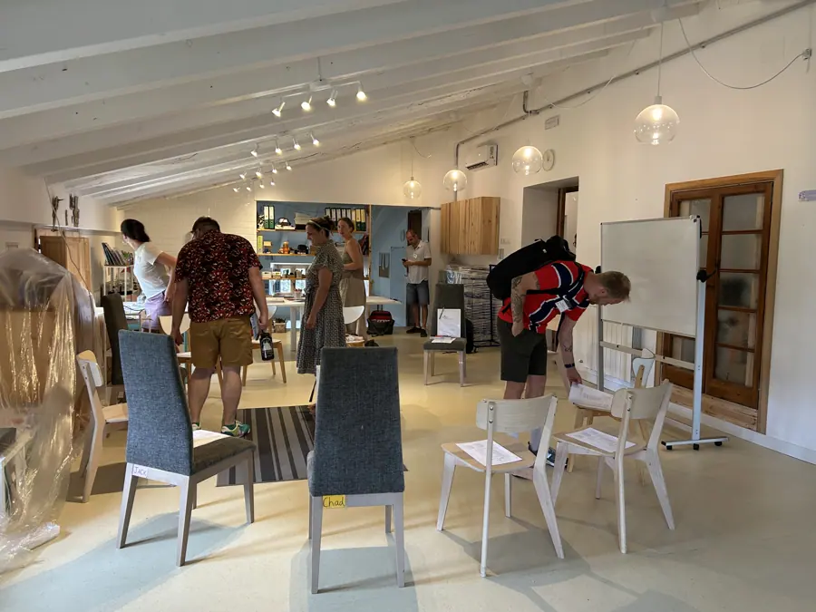 a bright studio room with participants moving between tables