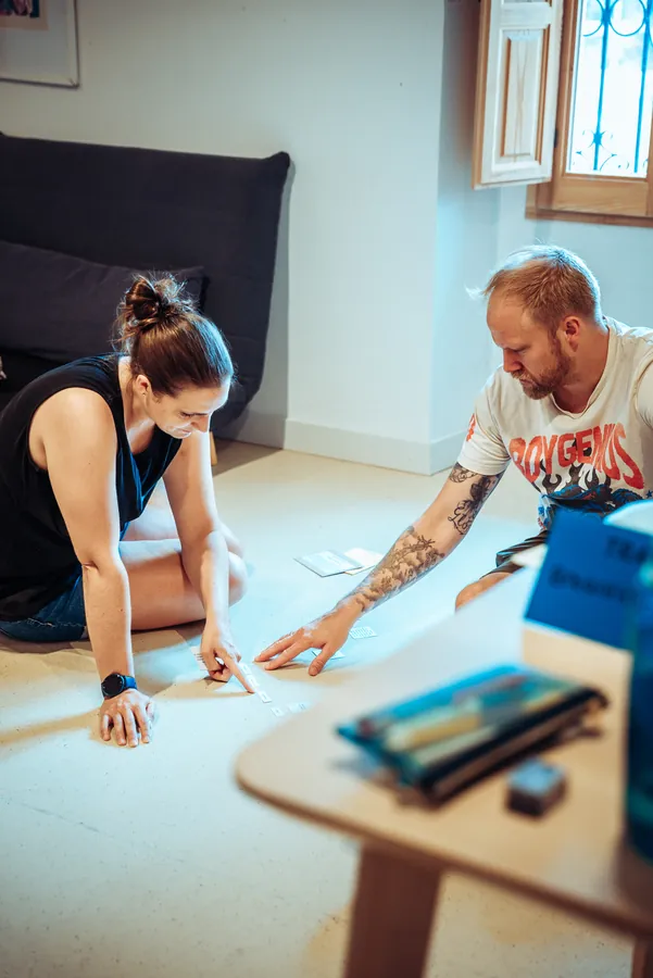 two participants working with a material on the floor
