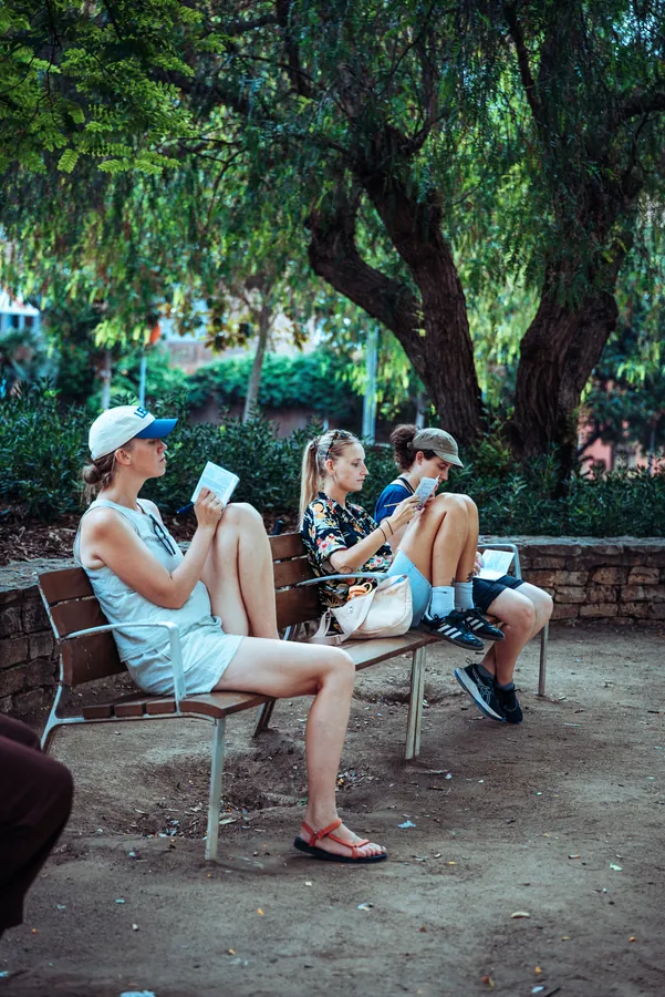 participants resting on a bench under the plane trees