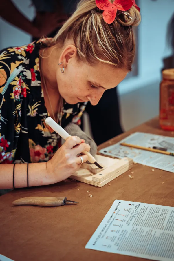 a participant carving a spoon with a chisel